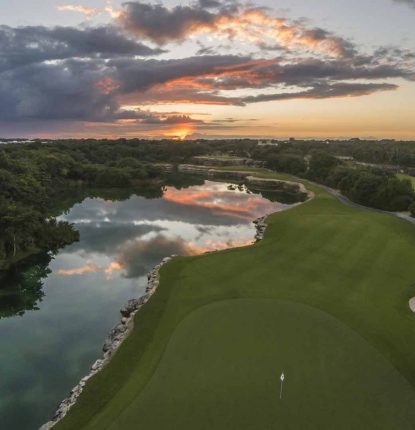 sunrise/sunset of hole 15 at PGA Riviera Maya. Features water on the left side of the hole