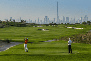Two golfers tee off to views of the Burj Khalifa at Dubai Hills Golf Club