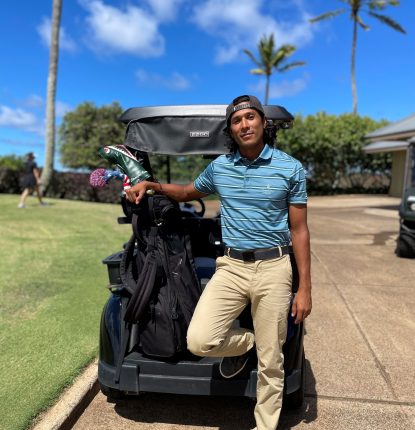 Juan Carlos Gonzalez standing behind a golf car