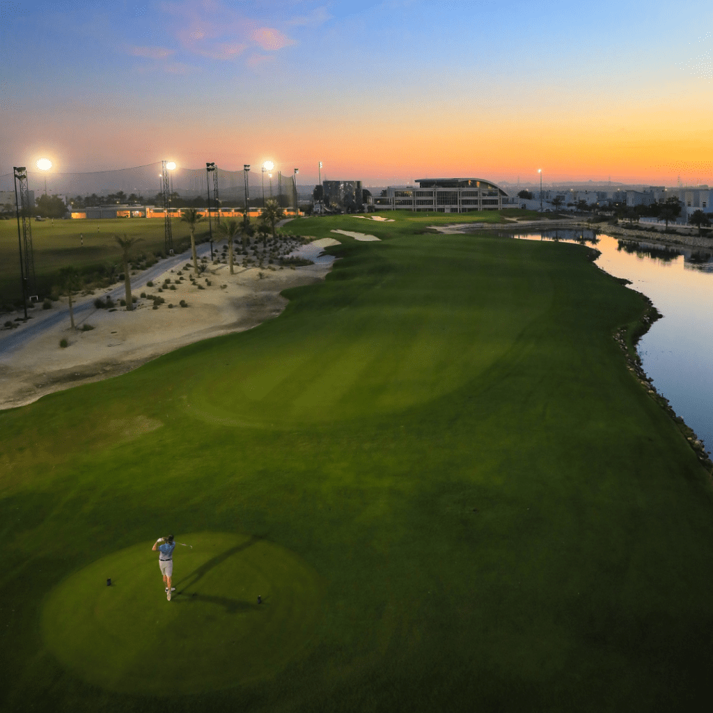 Golfer teeing off at sunset at Royal Golf Club Bahrain