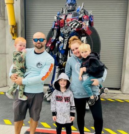 Danielle Enyeart and Family taking picture in front of Optimus Prime of the Transformers