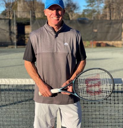 Mac Kantor Standing in front of a Tennis Net at Raintree Country Club