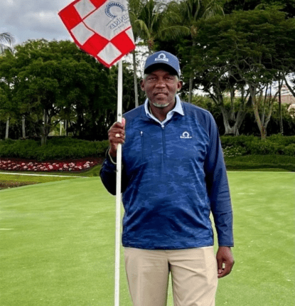 Albert Towns holding a golf flag